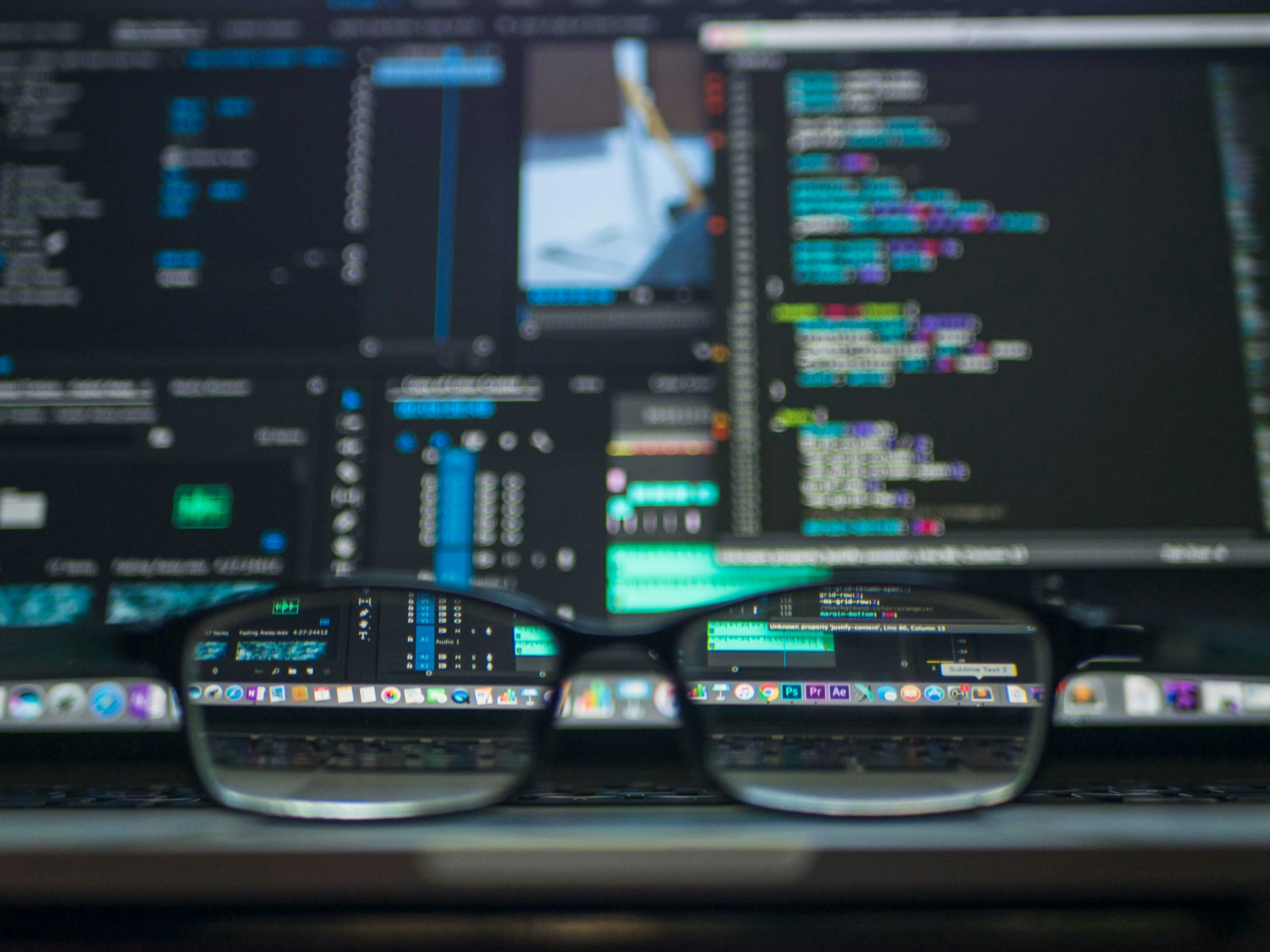 A data scientist pointing at a complex model diagram on a screen to a colleague.